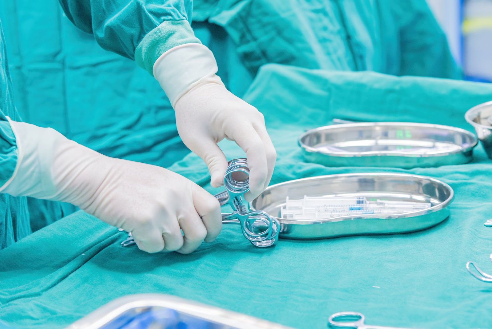 Gloved hands arranging surgical instruments on a tray